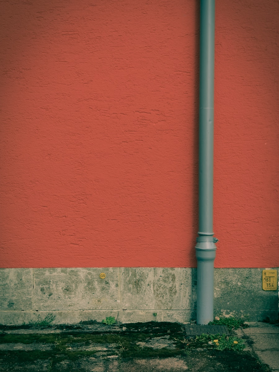 a red wall with a blue street light next to it